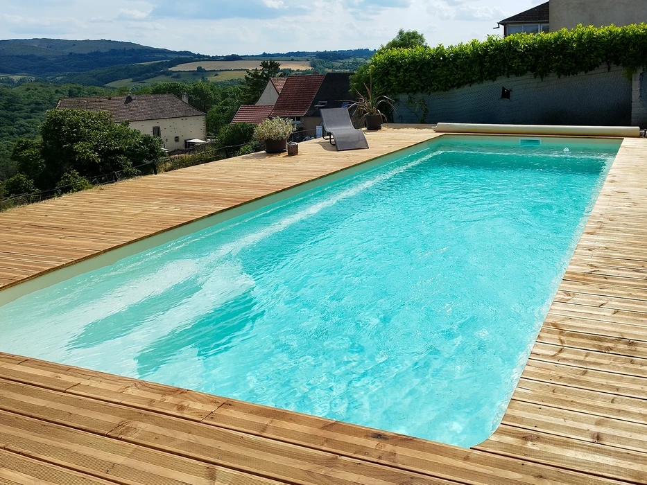 Couple en maillots de bain allongé sur plage de sable blanc, bras écartés, face à océan turquoise avec île montagneuse à l'horizon