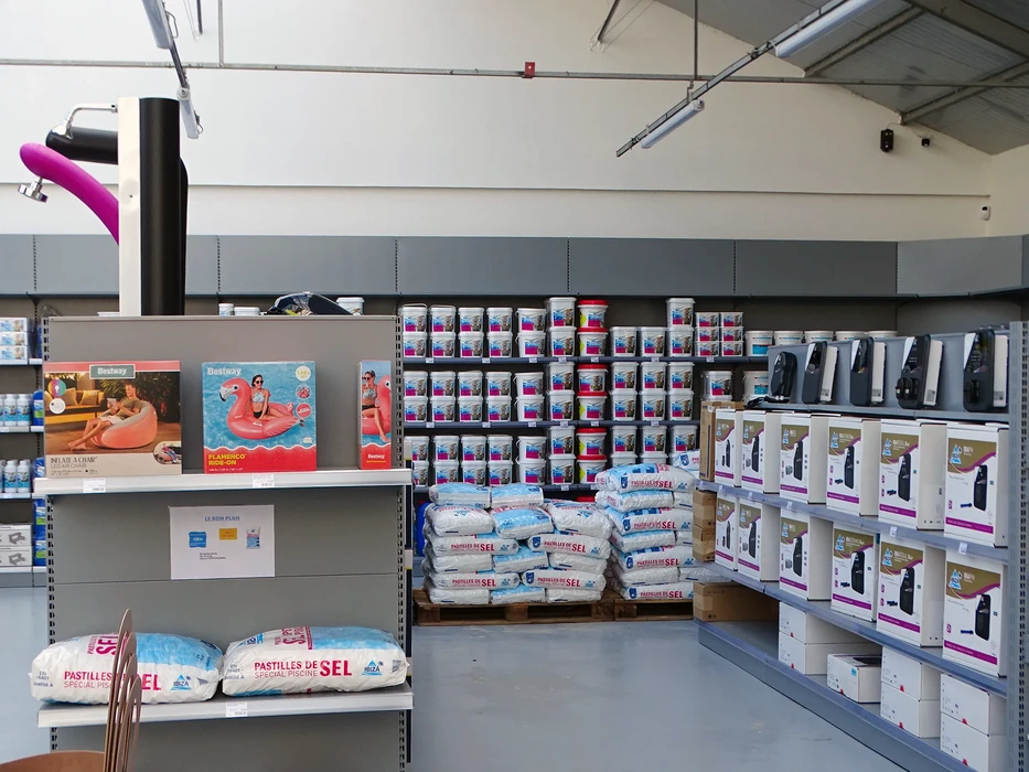 Famille heureuse dans une piscine en plein air, deux adultes et un enfant portant des lunettes de soleil colorées, jouant et éclaboussant l'eau sous le soleil