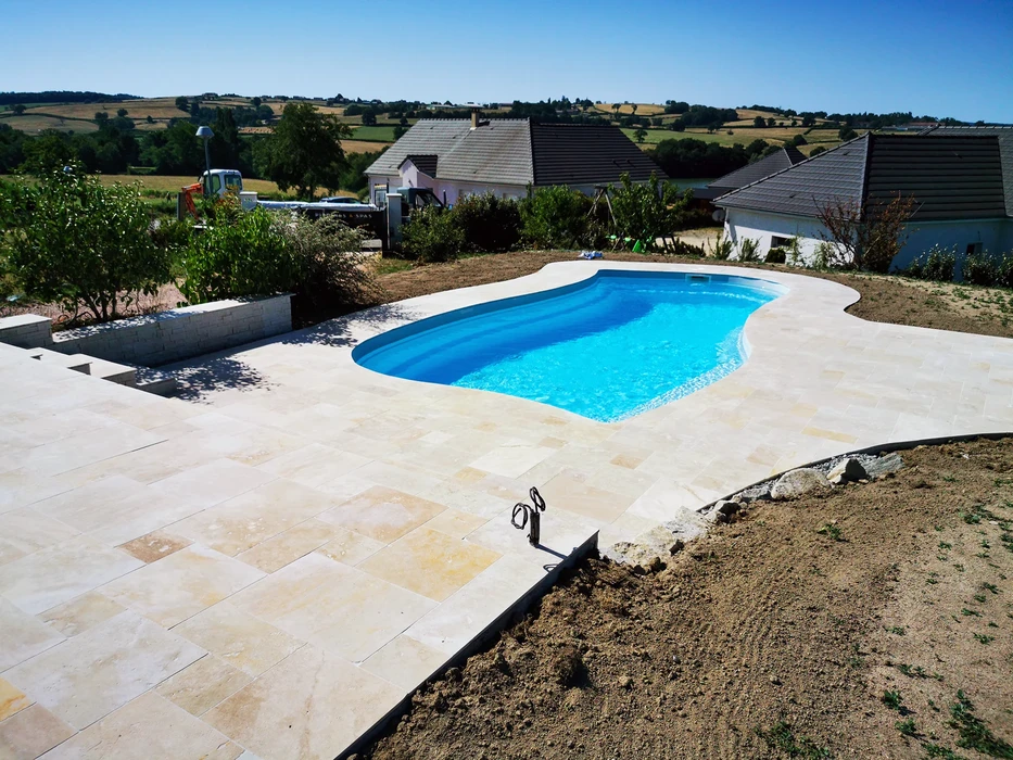 Piscine à débordement avec transats bleus et parasols beiges sur terrasse en bois