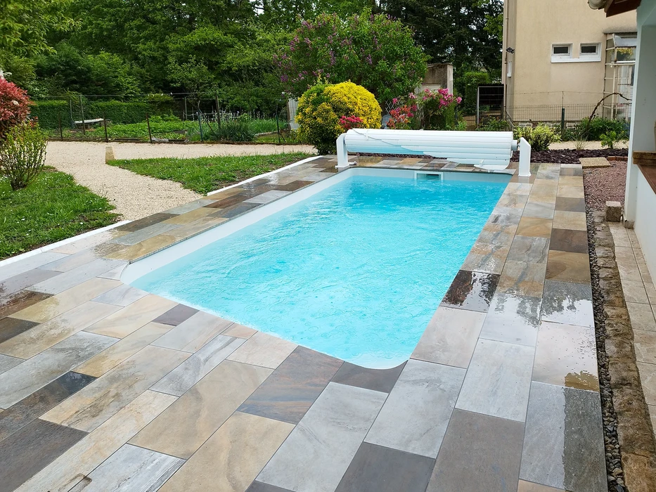 Piscine extérieure avec escalier métallique d'accès, eau cristalline turquoise, margelles en pierre claire